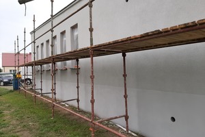 Zdjęcie przedstawia nową elewacje na sali wiejskiej w Kołaczkowicach i stojące tam rusztowania. (photo)