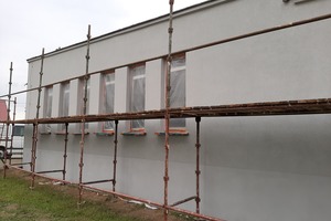 Zdjęcie przedstawia budynek sali wiejskiej w Kołaczkowicach oraz stojące tam rusztowana  (photo)