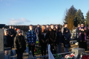 Zdjęcie grupy ludzi stojących obok grobu. (photo)