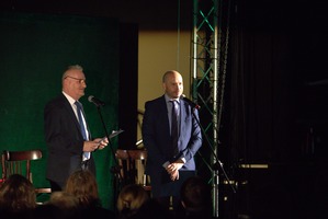 Zdjęcie przedstawia dwóch mężczyzn przemawiających przez mikrofony.  (photo)