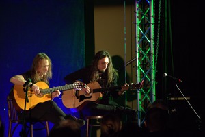 Zdjęcie przedstawia dwóch mężczyzn grających na gitarach. (photo)