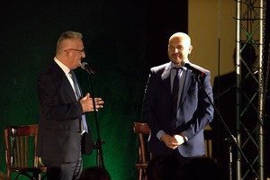 Zdjęcie przedstawia dwóch mężczyzn przemawiających przez mikrofony.  (photo)