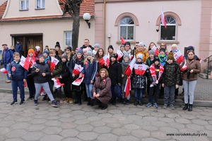 Zdjęcie przedstawia grupę ludzi z flagami Polski. (photo)