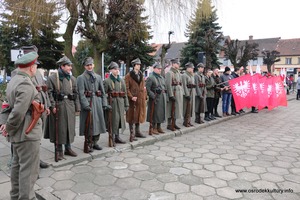 Zdjęcie przedstawia żołnierzy stojących na baczność z flagami Powstania Wielkopolskiego.  (photo)