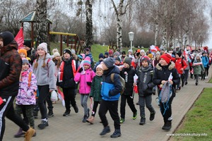 Zdjęcie przedstawia maszerujących ludzi z flagami Polski. (photo)
