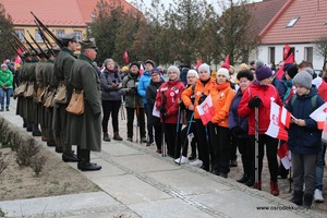 Zdjęcie przedstawia stojących na baczność żołnierzy na przeciwko grupy ludzi z flagami. (photo)