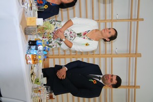 Na zdjęciu znajduje się kobieta i mężczyzna stojący za dożynkowym stołem odbierający wieniec (photo)