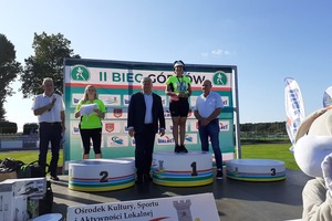 Zwyciężczyni biegów w kategorii kobiet na najwyższym stopniu podium wraz z burmistrzem i sponsorem biegu. (photo)