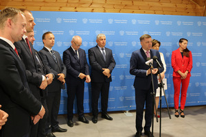 Poseł Tomasz Ławiczak w czasie przemówienia, dookoła niego pozostali uczestnicy spotkania słuchający przemówienia  (photo)