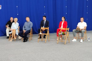 Na zdjęciu znajduje się grupa ludzi siedzących na drewnianych krzesłach. (photo)