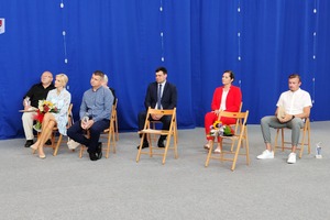Na zdjęciu znajduje się grupa ludzi siedzących na drewnianych krzesłach. (photo)