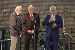 Na zdjęciu widoczni są trzej mężczyźni. Burmistrz Miejskiej Górki wręcza statuetkę (photo)