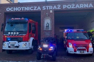 Na zdjęciu znajdują się dwa samochody ratowniczo-gaśnicze, pośrodku stoi quad (photo)