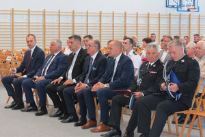 Uczestnicy wydarzenia siedzący na hali sportowej na krzesełkach (photo)