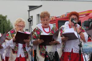 Zdjęcie przedstawia trzy Panie ubrane w tradycyjne stroje ludowe, które śpiewają. (photo)