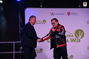 Zdjęcie przedstawia Burmistrza Gminy Miejska Górka witającego się z wokalistą jednego z zespołu mającego występ na scenie, podczas gali Liderów Wielkopolskiej Odnowy Wsi. (photo)
